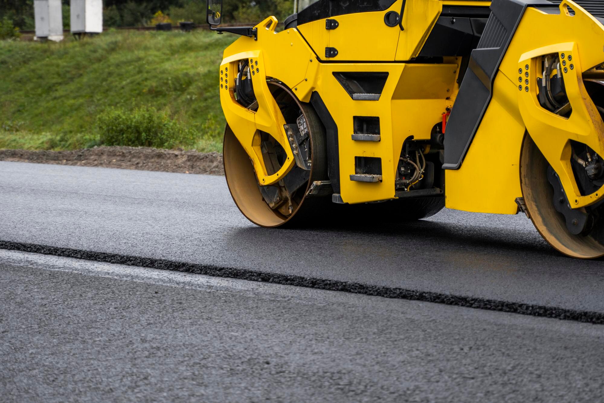 Representative asphalt paving equipment at work on a paved surface